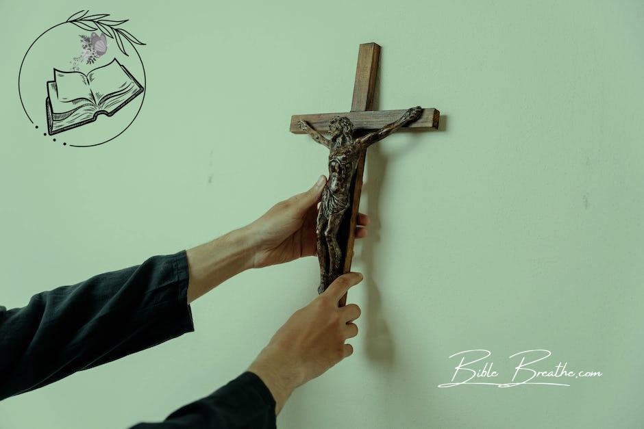 A Person Holding a Wooden Cross on a Wall