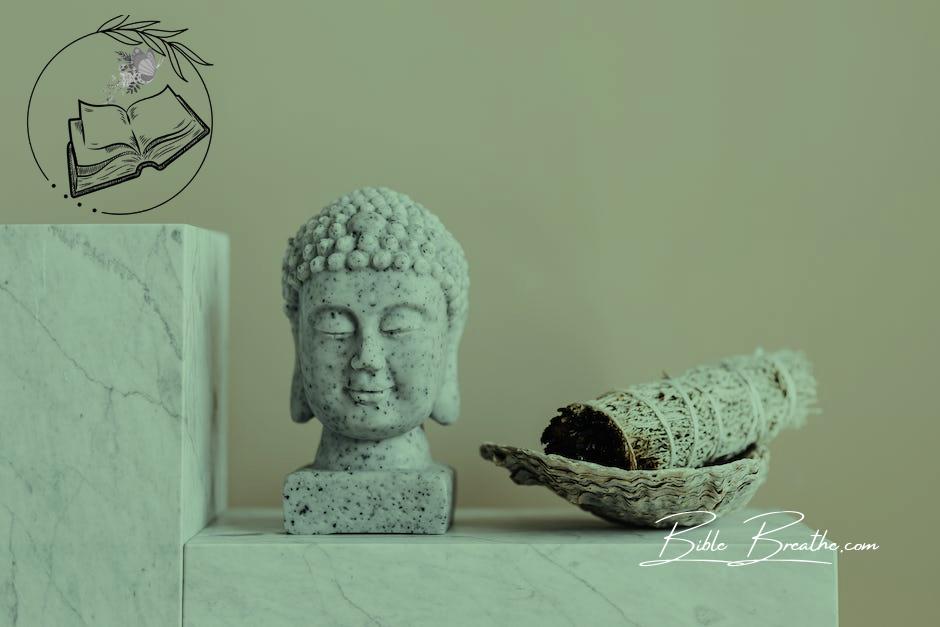 Stone Buddha and sage incense bundle in bowl on marble shelf