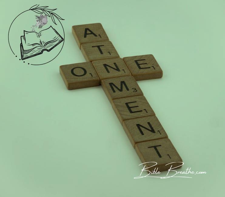 A cross made out of scrabble letters that says atonement