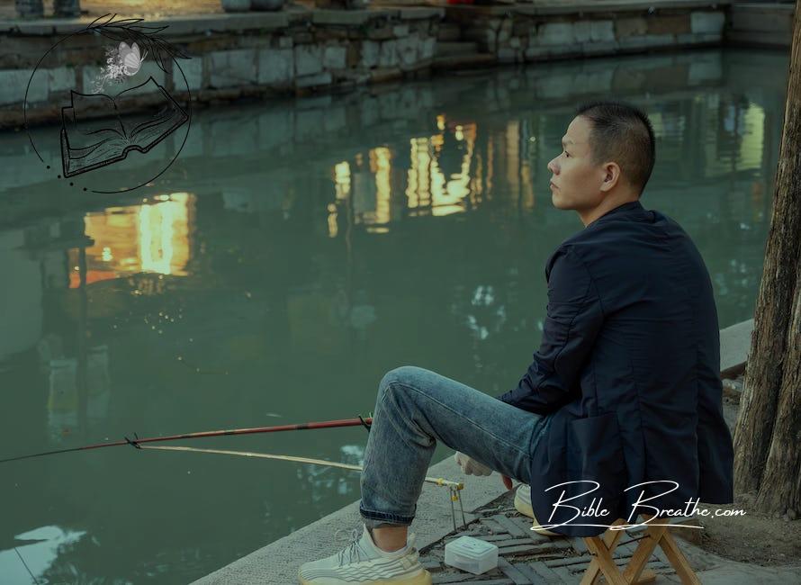 Pensive Man Sitting by a Canal with a Fishing Rod