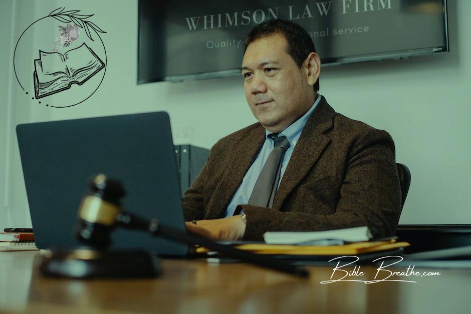 Positive Asian lawyer using laptop in modern office