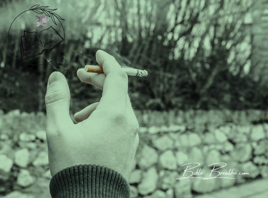Selective Color Photography of Person Holding Cigarette Stick