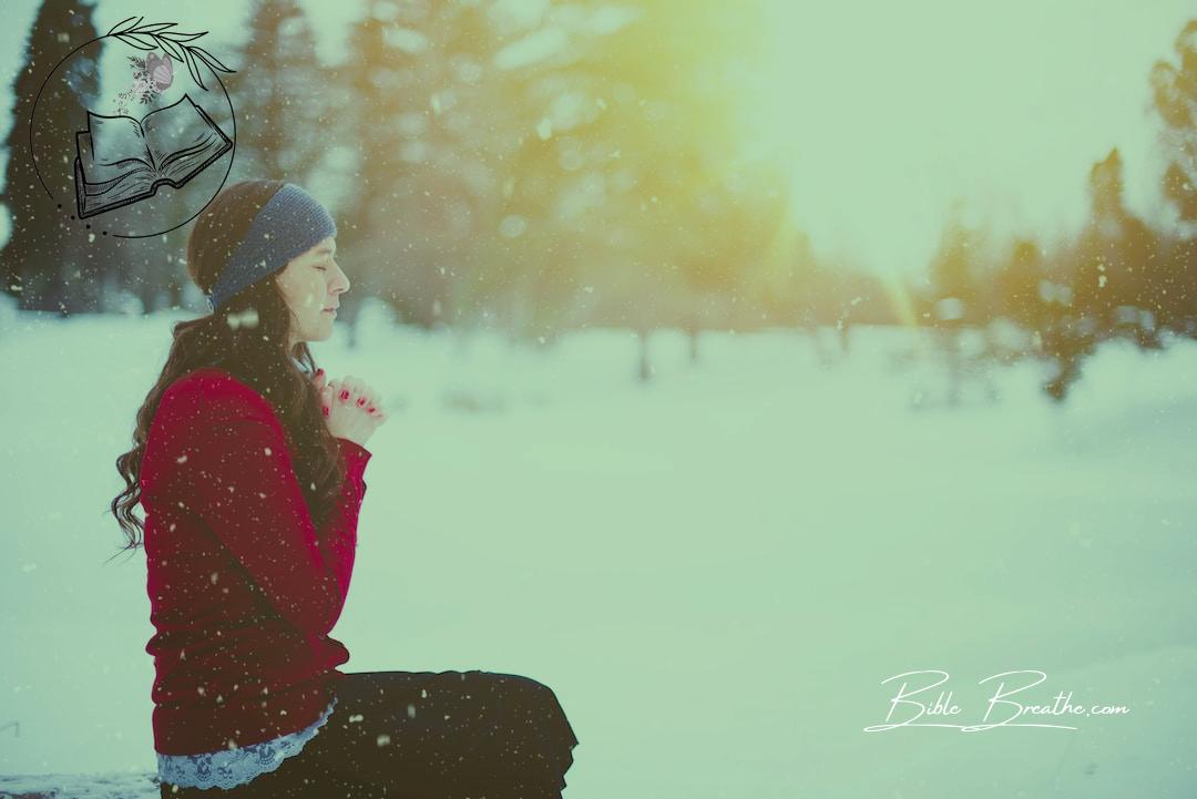 woman sitting with closed eyes surrounded by snow
