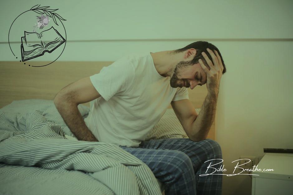 Young man in sleepwear suffering from headache in morning