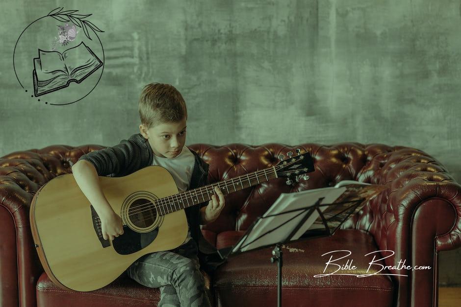 Kid Sitting on a Sofa Playing a Guitar