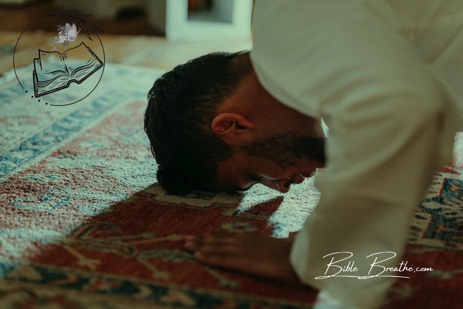 Man in White Dress Shirt Bowing Down on a Rug