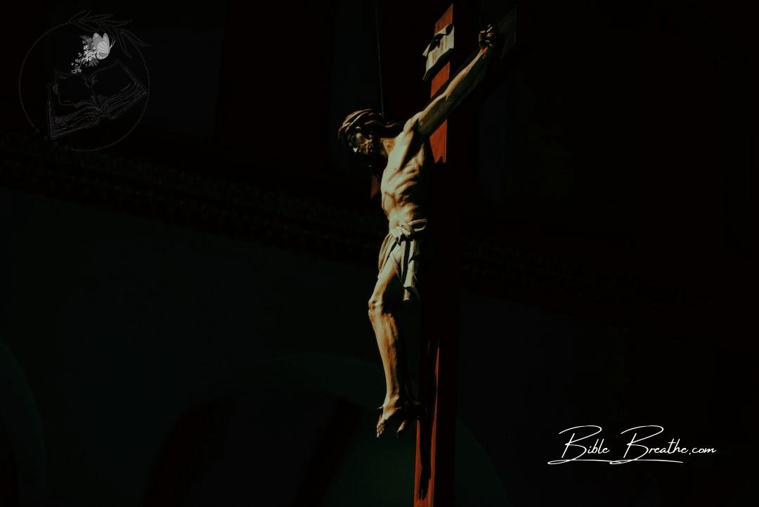 a statue of a man on a cross in the dark