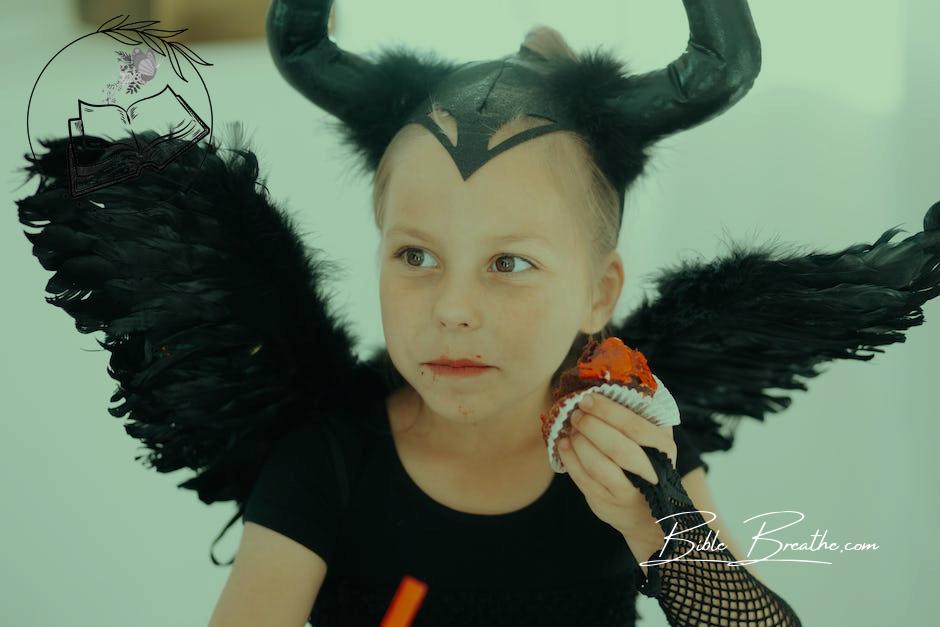 Girl in Devil Costume Eating a Cupcake