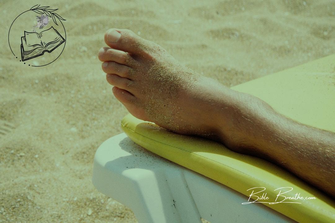 persons feet on yellow and white towel