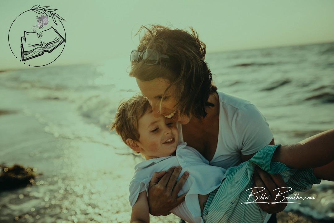 photo of mother and child beside body of water