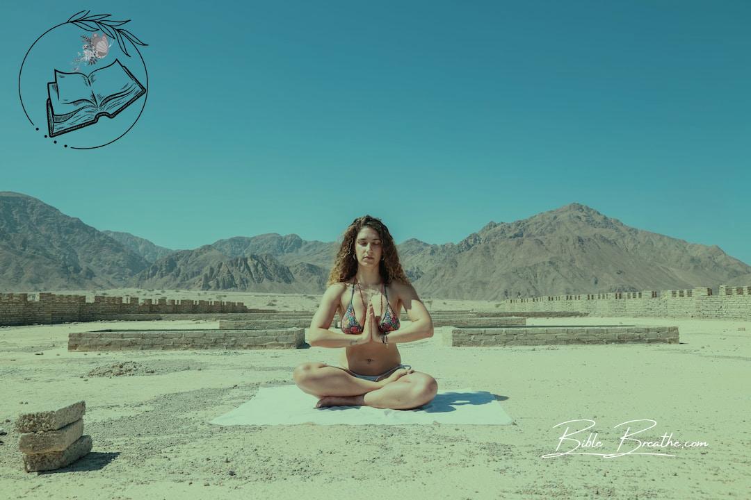 woman wearing two-piece meditating under blue sky during daytime