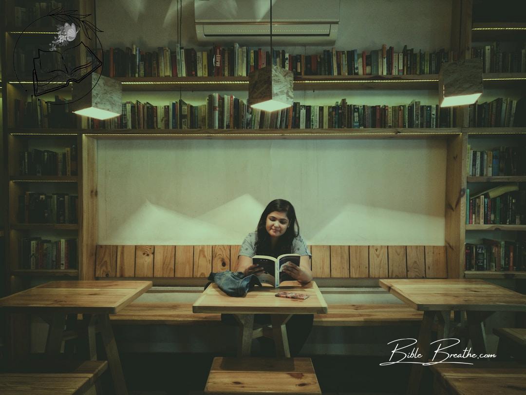 woman reading book inside the library