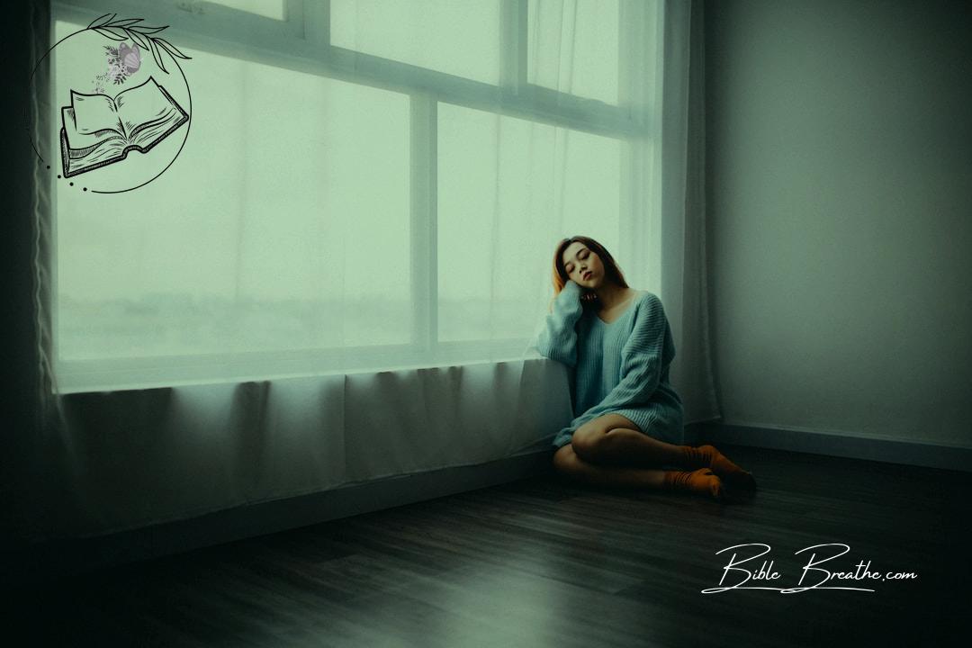 woman sitting on floor near window