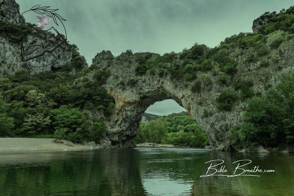 A large rock arch in the middle of a river