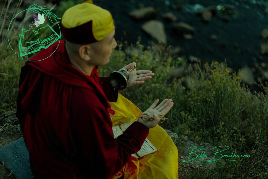 A Man Praying while Holding a Bell