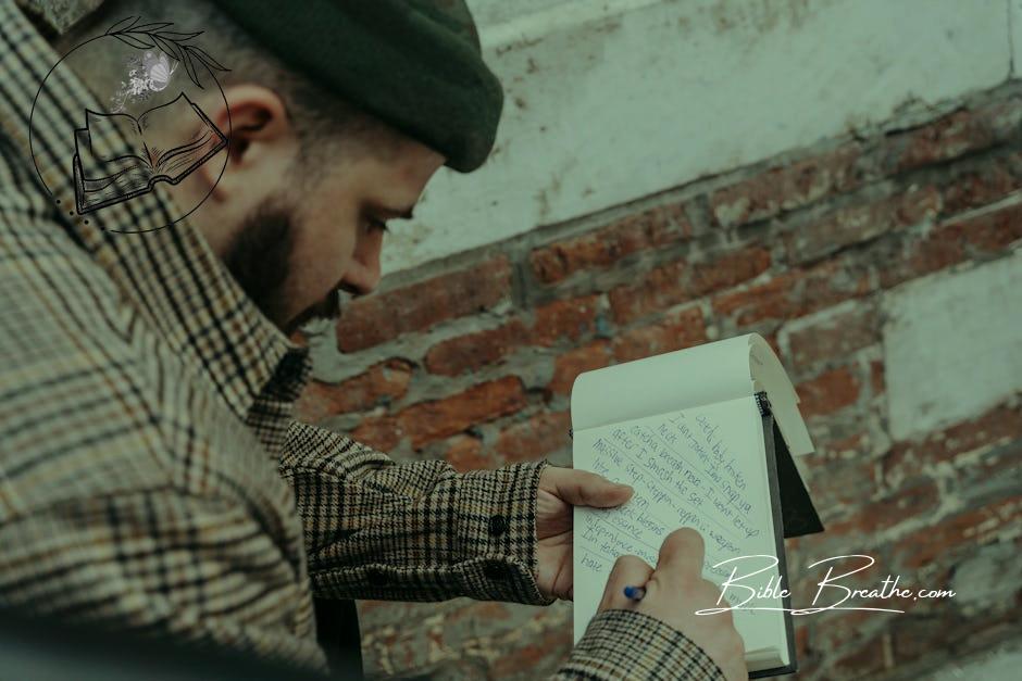 Man Writing Song Lyrics in Notebook